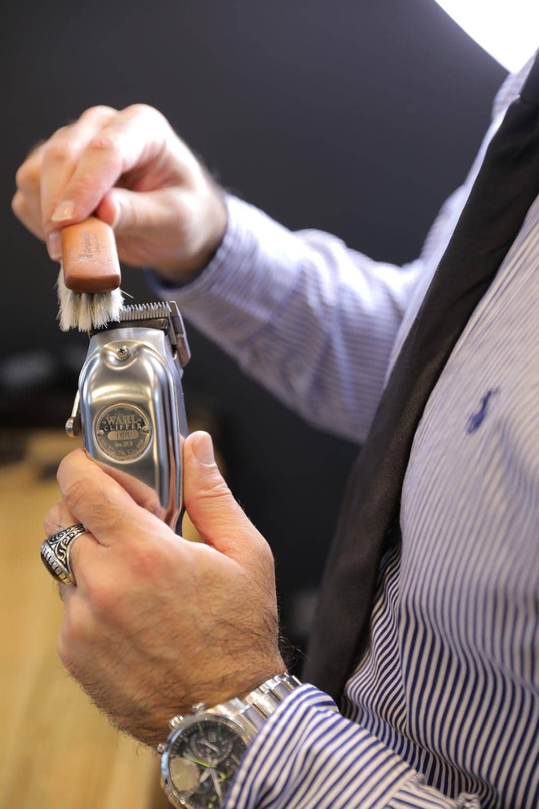 Hände reinigen eine Wahl-Haarschneidemaschine mit einer Bürste